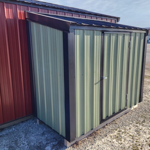 Metal storage shed beside red building