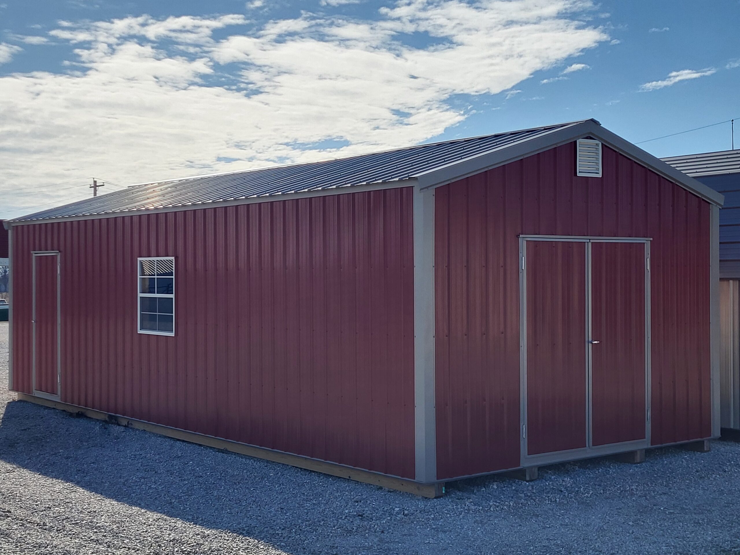 Red metal shed under blue sky